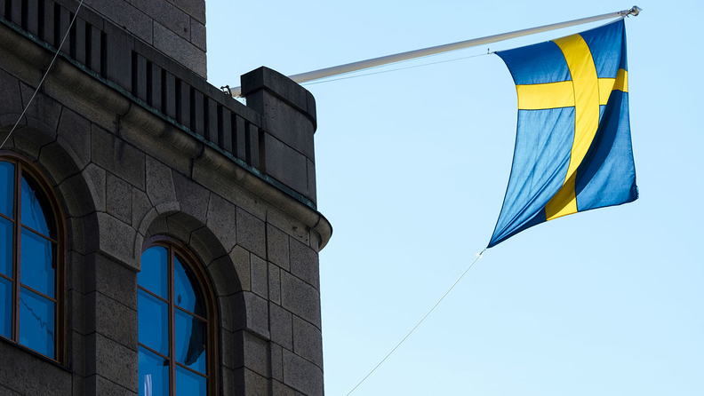 A national flag of Sweden hangs from a commercial building in Stockholm on June 28, 2017